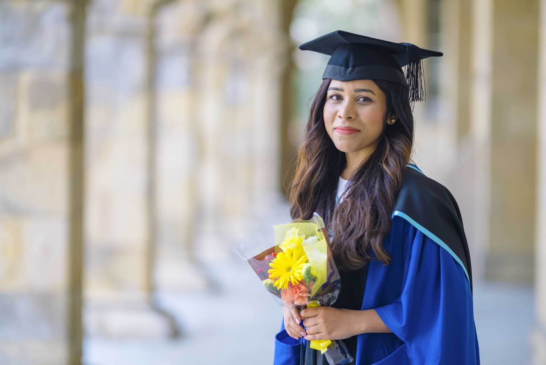 Rapariga com ramo de flores na cerimónia de licenciatura